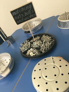 there are many different types of screws on the table with a sign that says matching nuts bolts and washers