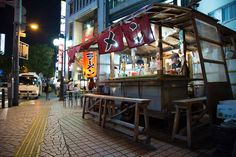 a food stand on the side of a street at night