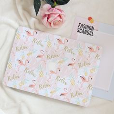 the pink flamingo macbook cover is next to a rose