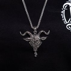 Stunningly intricate and made from durable alloy steel, the Goat Head Necklace boasts a large 2.5 by 2.3 inch pendant, complemented by a sturdy 25 inch double link chain. Premium craftsmanship exudes from every inch of this piece. Viking Style Oxidized Metal Necklaces, Viking Style Oxidized Metal Necklace, Symbolic Stainless Steel Jewelry With Large Pendant, Viking Style Metal Pendant Jewelry, Silver Viking Style Metal Necklace, Black Viking Metal Jewelry, Nickel-free Viking Style Stainless Steel Jewelry, Goat Head, Dark Elegance