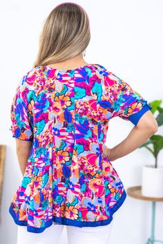 Product Details Colors: Blue, Teal, Orange, Hot Pink, Periwinkle, Purple, Brown Print: Floral Neckline: Round Sleeve: Short Sleeve Hemline: Straight Brand: Umgee Material and Care 100% Rayon Contrast: 100% Cotton Hand Wash Cold Hang/Line Dry Size and Fit Small: Bust 38" Waist 40" Front Length 25" Back Length 27" Medium: Bust 40" Waist 42" Front Length 25.5" Back Length 27.5" Large: Bust 42" Waist 44" Front Length 26" Back Length 28" Photo model is 5'7 and wearing a size small Flowy Multicolor Print Tops For Beach, Vibrant Patterned Tops For The Beach, Vibrant Blue Top For Beach, Spring Beach Tops With All Over Print, Blue Floral Print Tops For Vacation, All Over Print Tops For Beach In Spring, Summer Tops With All Over Print For Spring, Blue Tops With Colorful Pattern For Summer, All Over Print Tops For Beach And Spring