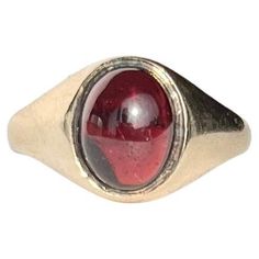 Sat proud upon a gorgeous glossy 9ct yellow gold band is an equally glossy garnet cabochon stone. The stone nearly spans the whole width of this ring. Made in Birmingham 1964, England. Ring Size: M 1/2 or 6 1/2 Band Width At Widest: 11mm Weight: 3.2g Gold Ruby Ring Oval Cabochon With Polished Finish, Classic Yellow Gold Signet Ring With Cabochon, Yellow Gold Ruby Signet Ring With Polished Finish, Formal Domed Signet Ring With Cabochon, Formal 14k Gold Oval Cabochon Dome Ring, 14k Gold Domed Signet Ring With Gemstone, Gold Oval Cabochon Birthstone Ring, Classic Cabochon Opal Ring For Formal Occasions, Classic 14k Gold Signet Ring With Cabochon