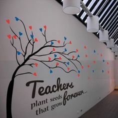 there is a tree with hearts painted on the wall and words written in different languages