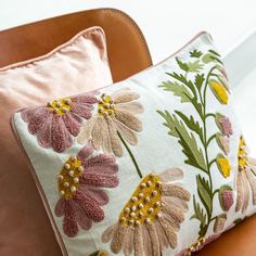 two pillows sitting on top of a brown couch