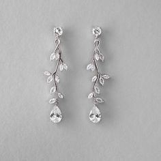 Create a stunning bridal look with our Long Vine CZ Wedding Earrings. These earrings are delicately crafted with a vine of marquise leaves featuring a single pear-cut CZ stone, that adds a touch of elegance to any wedding ensemble. They are about 2.5 inches long, rhodium or gold plated, made with AAA CZ stones, and lead, nickel, and cadmium free. Modern Wedding Earrings Bridal, Wedding Earrings Bride, Spring Ball, Vine Earrings, Silver Earrings Wedding, Boho Wedding Earrings, Long Bridal Earrings, Silver Bridal Earrings, Formal Earrings