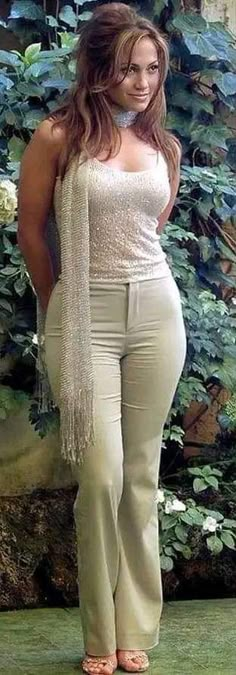 a woman is standing in front of some plants