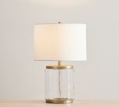 a lamp that is on top of a wooden table next to a white and gold lamp