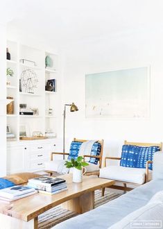 a living room with two couches and a coffee table in front of a book shelf