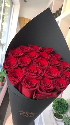 a large bouquet of red roses in a black box