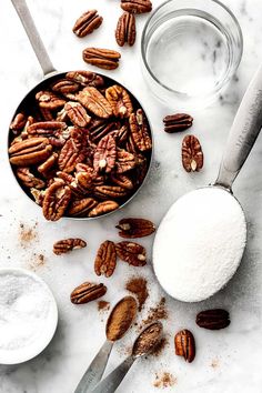 pecans, sugar and spoons on a marble surface