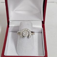 an engagement ring in a red velvet box on a white surface with the lid open