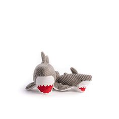 a stuffed shark toy laying on top of it's back with its mouth open