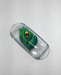 a glass case with a colorful design on the front and back sides, sitting on a white surface