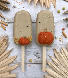 two popsicles decorated with pumpkins and leaves