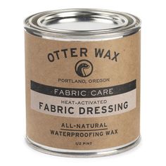 an open can of fabric dressing on a white background with the words, otter wax