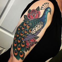 a woman with a peacock and roses tattoo on her arm