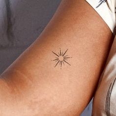 a woman's arm with a small star tattoo on the left side of her arm