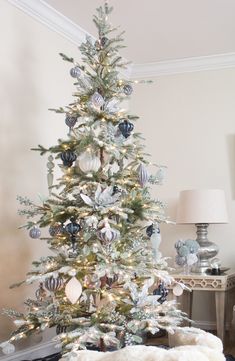 a white christmas tree with blue and silver ornaments