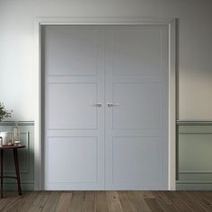 an empty room with white doors and wood flooring on the wooden floor next to a table