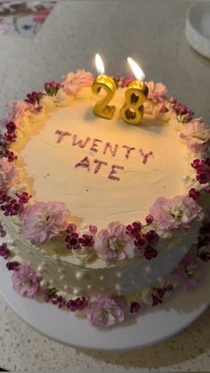 a birthday cake with two candles on it that says twenty aff and flowers around the edges