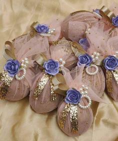 several pink and blue flowers are on top of some fabric balls with gold sequins