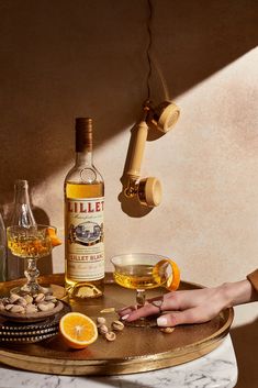 a table topped with a bottle of booze next to a glass filled with liquid