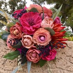 a bouquet of flowers sitting on top of a rock