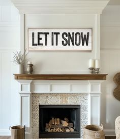 a living room with a fire place and a sign on the wall that says let it snow