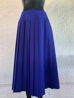 Vintage Mary McFadden pleated yoke skirt with side button closure and one side pocket.  78/22% Polyester/Rayon Measurements lying flat: Waist: 13 inches Length: 31.5 inches Size: 10 This item is in good vintage condition! All items are stored in a smoke-free environment   Lowbrow Vintage is based in Tucson, Arizona, and is an entirely independent and family run business. At Lowbrow Vintage, we focus on curating a unique and funky aesthetic, while still leaving room for comfort and charm. We hope that these wonderful pieces are appreciated once again in the cycle of vintage love. We care deeply about vintage fashion and do our best describe and photograph each item with care and detail. Our pieces are well loved ready and waiting for a new life in the cyclical nature of fashion. Don't hesit Fitted Blue Bottoms With Accordion Pleats, Formal Box Pleat Skirt For Summer, Blue Skirted Bottoms With Pleated Hem, Blue Full Skirt With Accordion Pleats, Summer Formal Pleated Skirt With Box Pleat, Spring Full Length Fitted Pleated Skirt, Blue Skirted Bottoms With Pleated Waist, Retro Blue Pleated Skirt, Blue Relaxed Pleated Skirt With Accordion Pleats