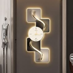 a clock that is on the side of a wall next to a door with lights