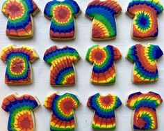 tie dye cookies are arranged in rows on a white surface, each decorated with an individual's t - shirt