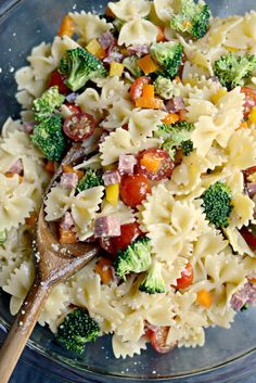 pasta salad with ham, broccoli and tomatoes in a glass bowl