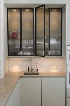 a kitchen area with sink, cabinets and cupboards on the wall in front of it