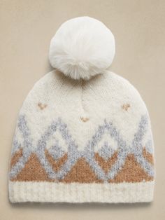 a knitted hat with a pom - pom on the top is shown