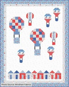 a quilted wall hanging with red, white and blue kites in the shape of houses