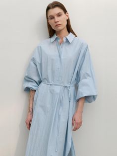 This long shirt dress from Atelier Nain features a wide placket and a half-open design, offering comfort without the gap between buttons.- With a belt to accentuate the waistline- Oversized fit for comfortable wear experience- The uneven hemline to add a unique point of interest* Model shots may differ from the actual product color due to shooting location, time, and graphic techniques. Refer to the product cut images for the actual color. Summer Cotton Shirt Dress With Belted Cuffs, Spring Button-up Shirt Dress With Cuffed Sleeves, Spring Shirt Dress With Cuffed Sleeves And Button-up, Summer Shirt Dress With Belted Cuffs For Daywear, Summer Daywear Shirt Dress With Cuffed Sleeves, Midi Length Shirt Dress With Cuffed Sleeves For Daywear, Summer Shirt Dress With Cuffed Sleeves For Daywear, Spring Midi Shirt Dress With Roll-up Sleeves, Relaxed Fit Shirt Dress With Tie Waist For Daywear