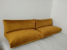 a yellow couch sitting on top of a white bed