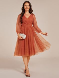 a woman in an orange dress is posing for the camera