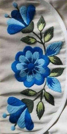 blue flowers on white fabric with green leaves