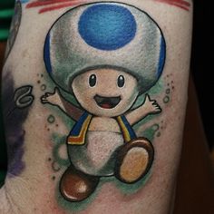 this is an image of a mushroom tattoo on someone's leg and it looks like they are playing video games