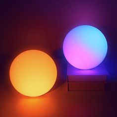 an illuminated ball sitting on top of a table next to a lit up box with it's lid open