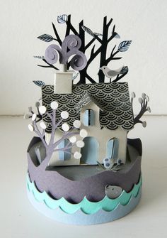 a paper house with trees and birds on it