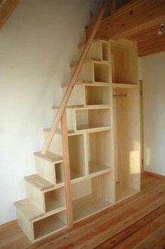 an empty room with some shelves on the wall and stairs in the floor to the second floor