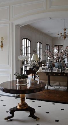 a living room filled with lots of furniture next to a fire place and chandelier