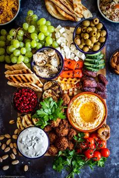 a platter with different types of food on it, including olives, bread and crackers