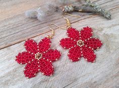 red beaded flower earrings sitting on top of a wooden table