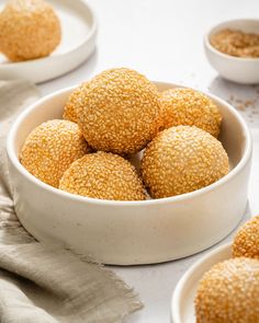 small white bowls filled with sesame sprinkles on top of a countertop