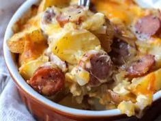 a close up of a bowl of food with sausage and potato casserole in it