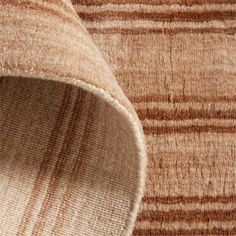 an area rug with brown and beige stripes on it's edges, close up