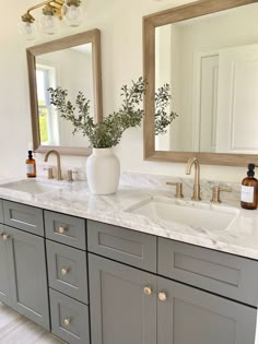 a bathroom with double sinks and two mirrors